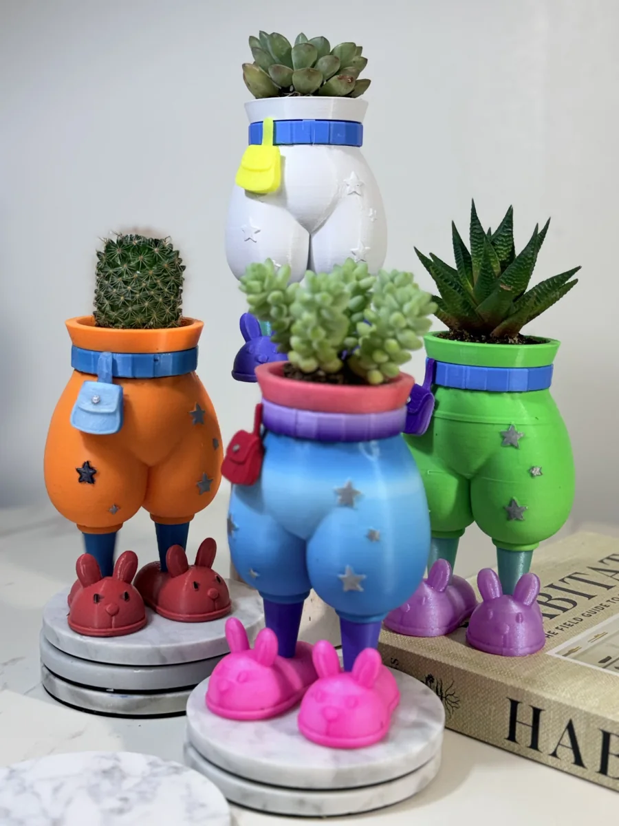A group of colorful rounded pants planters with small houseplants and bunny slippers