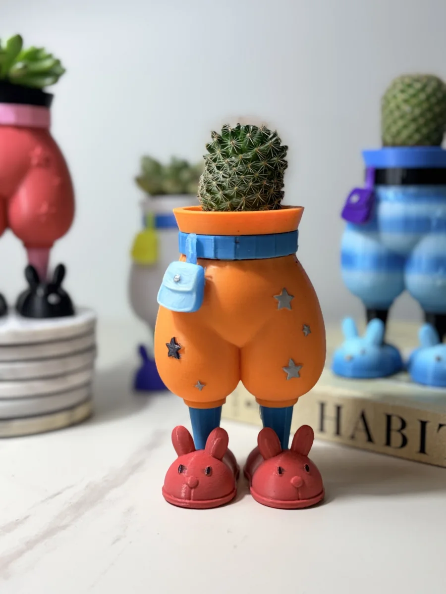 Original photograph of the orange pants planter with a cactus and red bunny slippers