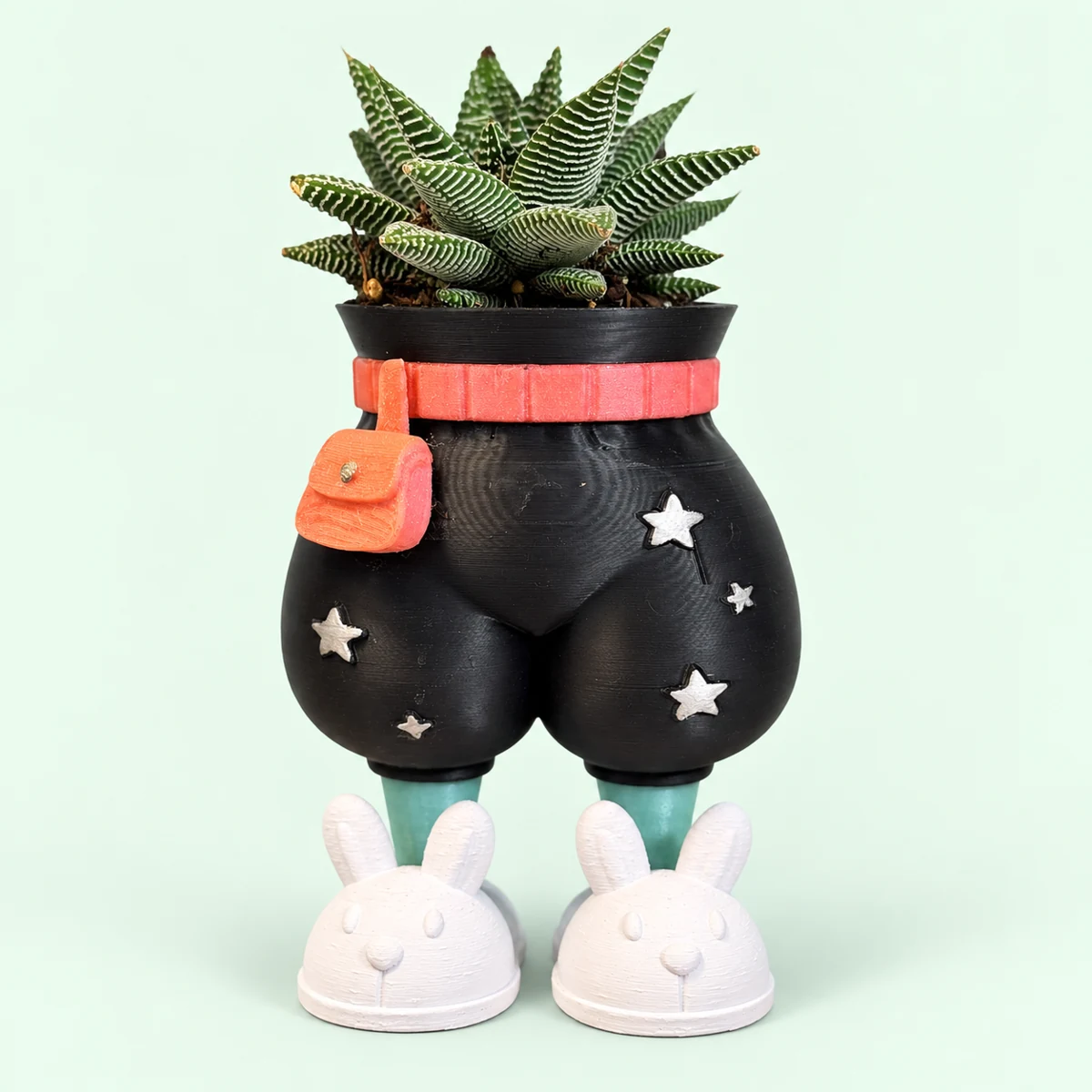 Black fat pants planter with a wide rounded silhouette, coral belt and bag, silver stars, mint shins and white bunny slippers