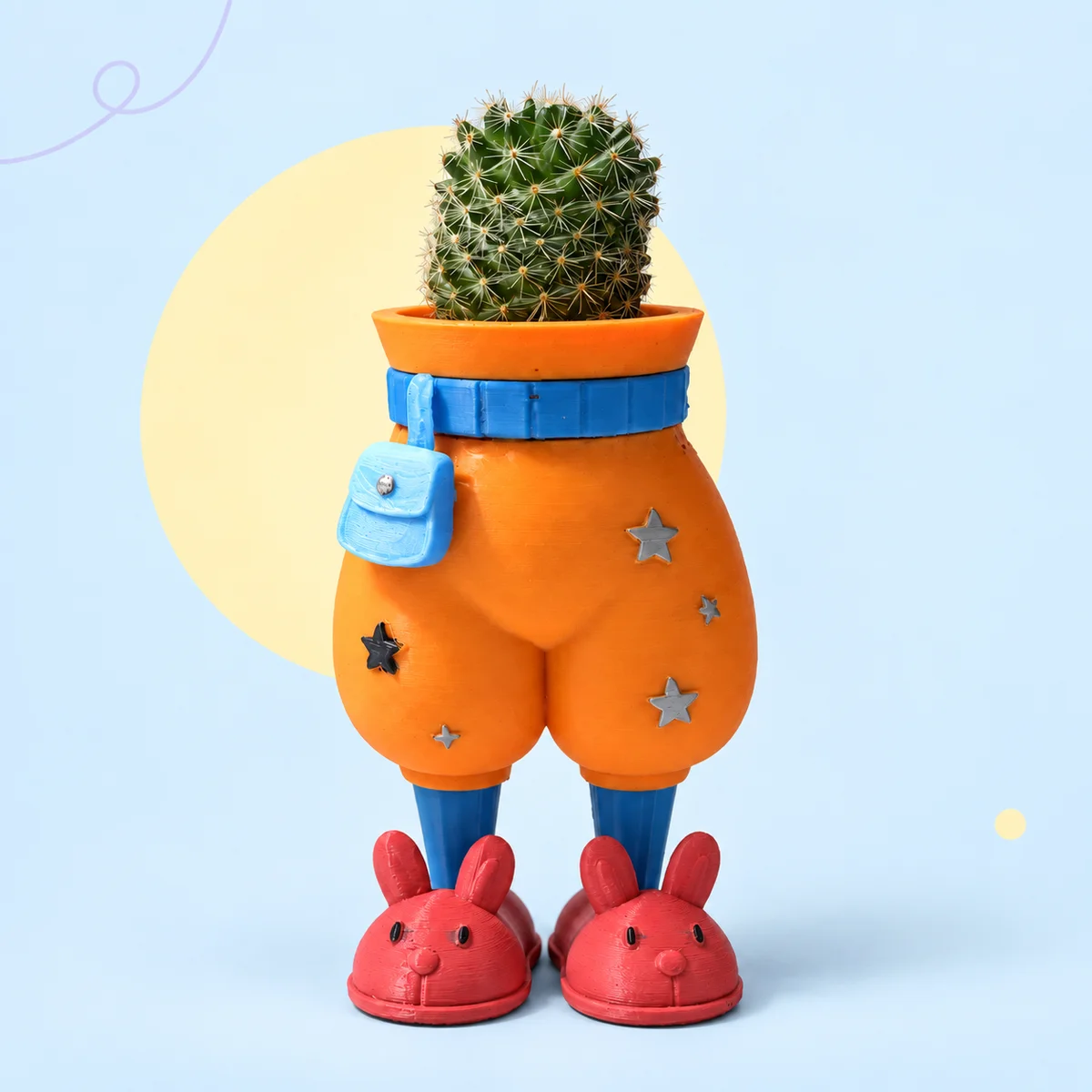 Orange Sidekick pants planter with a blue mini bag and belt, star details, blue shins and red bunny slippers, holding a cactus